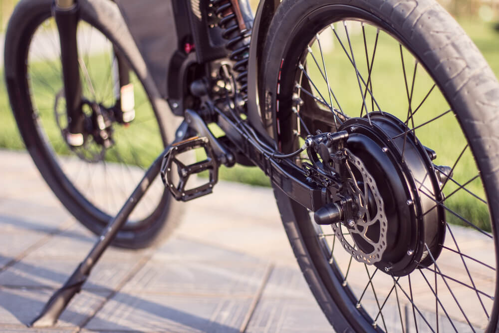 Nahaufnahme des Hinterrads eines E-Bikes mit Motor, Bremsscheibe, Pedal und Ständer - relevant für Gutachter nach Unfall mit Fahrrad